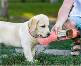 Portable pet water bottle used by a Labrador puppy outdoors.