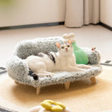 Cat lounging on a plush wooden pet bed with soft cushions.