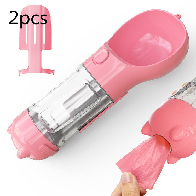 Portable pink pet water bottle with feeder bowl and garbage bag storage, ideal for outdoor travel.