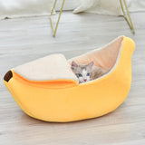 Removable and washable banana-shaped pet nest in yellow with a cat inside.